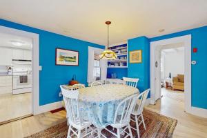 a dining room with blue walls and a table and chairs at Gingerbread Dream in Oak Bluffs