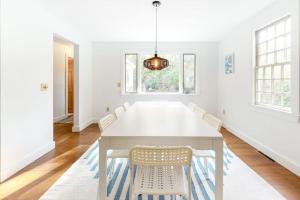 a dining room with a white table and chairs at Wellfleet Harbor Hideaway in Wellfleet