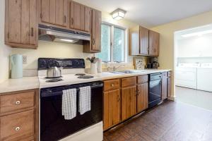 a kitchen with wooden cabinets and a black stove top oven at Wellfleet Harbor Hideaway in Wellfleet +23 photos