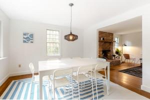 a white dining room with a white table and chairs at Wellfleet Harbor Hideaway in Wellfleet