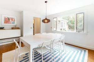 a white dining room with a white table and chairs at Wellfleet Harbor Hideaway in Wellfleet