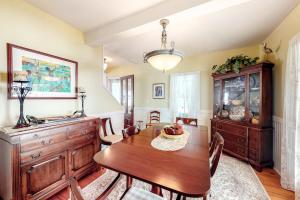a dining room with a wooden table and a chandelier at Island Dream in Oak Bluffs