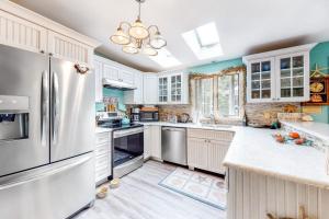 a kitchen with white cabinets and a refrigerator at Summer Daze in Edgartown +17 photos