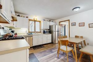 a kitchen with white cabinets and a table and a refrigerator at Fallen Oak Retreat in Oak Bluffs +14 photos