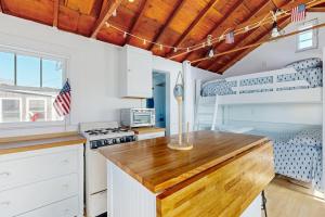 a kitchen with white cabinets and a wooden counter top at Beach Days in Dennis Port
