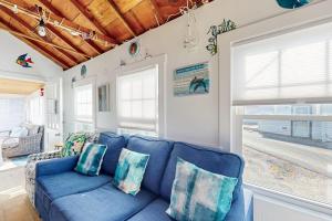 a blue couch in a living room with a window at Beach Days in Dennis Port