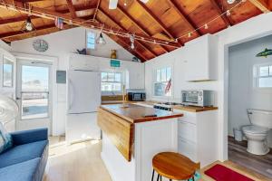 a kitchen with white cabinets and a blue couch at Beach Days in Dennis Port +11 photos