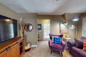 a living room with a purple couch and a tv at Provincetown Bliss in Provincetown