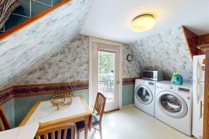 a laundry room with a washing machine and a table at Provincetown Bliss in Provincetown +10 photos