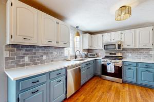 a kitchen with white cabinets and blue appliances at Megansett Glen in North Falmouth +29 photos