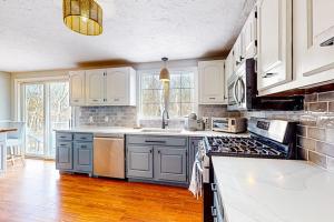 a kitchen with white cabinets and a stove top oven at Megansett Glen in North Falmouth