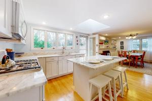 a large kitchen with white cabinets and a kitchen island at Saltwater Haven in Orleans