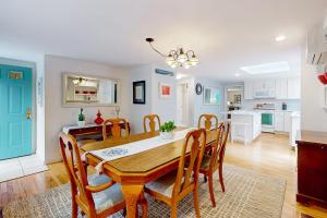 a dining room and kitchen with a table and chairs at Saltwater Haven in Orleans +19 photos
