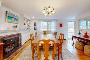 a dining room with a table and a fireplace at Saltwater Haven in Orleans