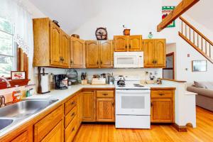 eine Küche mit Holzschränken und einem weißen Herdofen in der Unterkunft Haven Cottage in Brewster