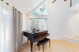 a black piano in a room with a window at Tiffany's Treasure in Oak Bluffs