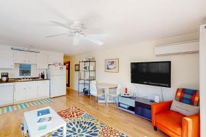 a living room with a flat screen tv and a kitchen at Beach Blessing in Provincetown