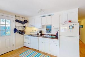 a kitchen with white cabinets and a white refrigerator at Beach Blessing in Provincetown