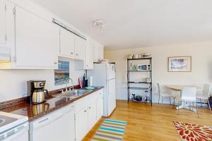 a kitchen with white cabinets and a table with a dining room at Beach Blessing in Provincetown +21 photos