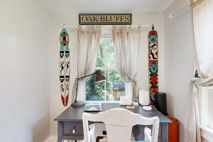 a desk with two white chairs in a room with a window at Sankofa House in Oak Bluffs