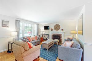 a living room with two couches and a fireplace at Falmouth Beach House in Falmouth
