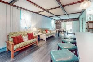 a living room with a couch and chairs and a table at Falmouth Beach House in Falmouth