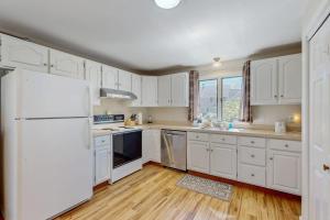 a kitchen with white cabinets and a white refrigerator at Peace & Serenity in Falmouth