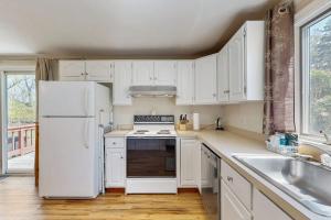 a kitchen with white cabinets and a white refrigerator at Peace & Serenity in Falmouth