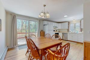 a kitchen and dining room with a wooden table and chairs at Peace & Serenity in Falmouth +27 photos