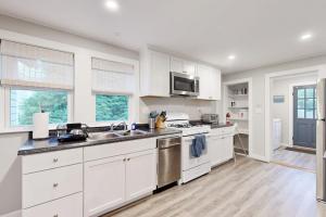 a white kitchen with a sink and a stove at Seabreeze Escape in Barnstable