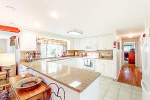 a kitchen with white cabinets and a large counter top at Falmouth Beachtown Getaway in Falmouth