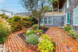 a garden with a brick walkway in front of a house at Bayview Bliss in Provincetown