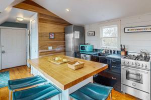 a kitchen with a counter with blue chairs in it at Bayview Bliss in Provincetown