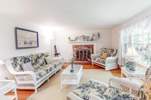 a living room with white furniture and a fireplace at Falmouth Beachtown Getaway in Falmouth +22 photos