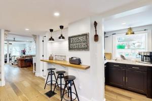 a kitchen with a counter and stools in a room at Sankofa Martha's Vineyard in Oak Bluffs +28 photos