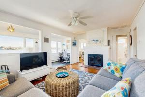 a living room with a couch and a tv at SEA-esta in Falmouth
