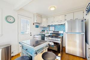 a kitchen with white cabinets and a white refrigerator at SEA-esta in Falmouth