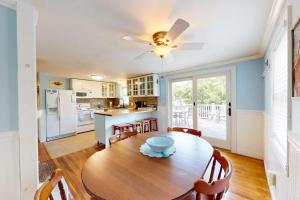 a kitchen and dining room with a table and a ceiling fan at Meet Me at the Cape in Barnstable