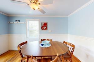a dining room with a wooden table and chairs at Meet Me at the Cape in Barnstable
