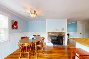 a dining room with a table and a fireplace at Meet Me at the Cape in Barnstable