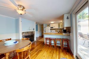 a kitchen and dining room with a table and chairs at Meet Me at the Cape in Barnstable