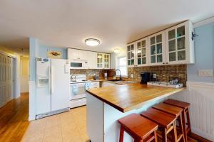 a kitchen with white appliances and a wooden counter top at Meet Me at the Cape in Barnstable +21 photos