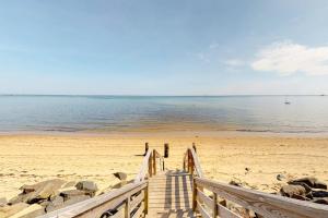 a wooden boardwalk leading to a beach with the ocean at Endless Summer in Provincetown
