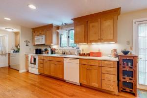a large kitchen with wooden cabinets and white appliances at Island Oasis in Edgartown