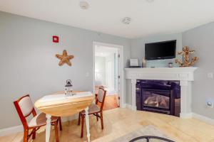 a living room with a table and a fireplace at Immaculate Beach Condo in Dennis Port