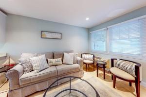 a living room with a couch and a table at Immaculate Beach Condo in Dennis Port +15 photos