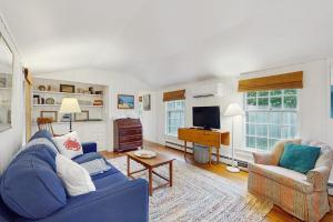 a living room with a blue couch and a television at Little Cozy Corner in Edgartown
