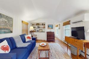 a living room with a blue couch and a tv at Little Cozy Corner in Edgartown