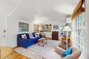 a living room with a blue couch and a table at Little Cozy Corner in Edgartown