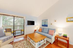ein Wohnzimmer mit Sofa und Tisch in der Unterkunft Ocean Mandevilla in Brewster